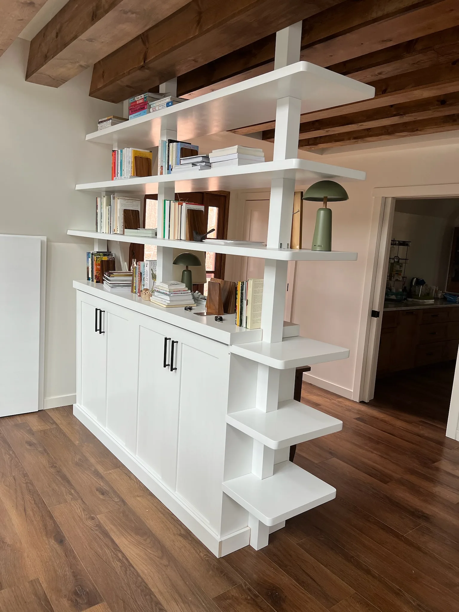Angled view of bookshelf room divider cabinet base and open shelving by Sims Custom Woodwork.