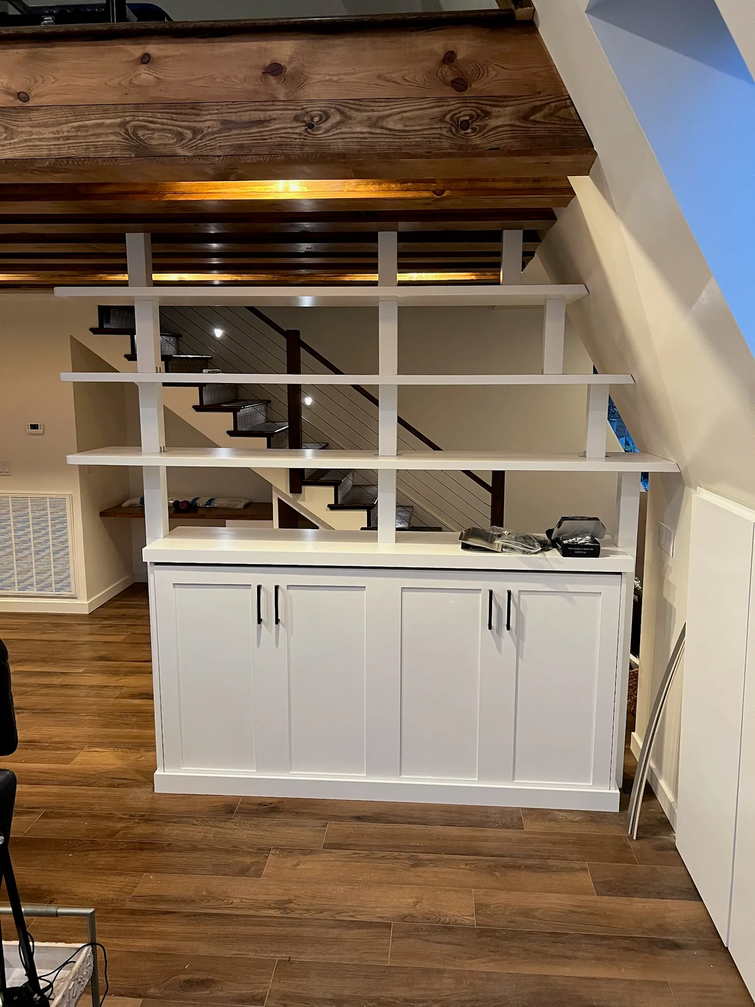 Elevated view of bookshelf room divider with open shelving and cabinet base by Sims Custom Woodwork.
