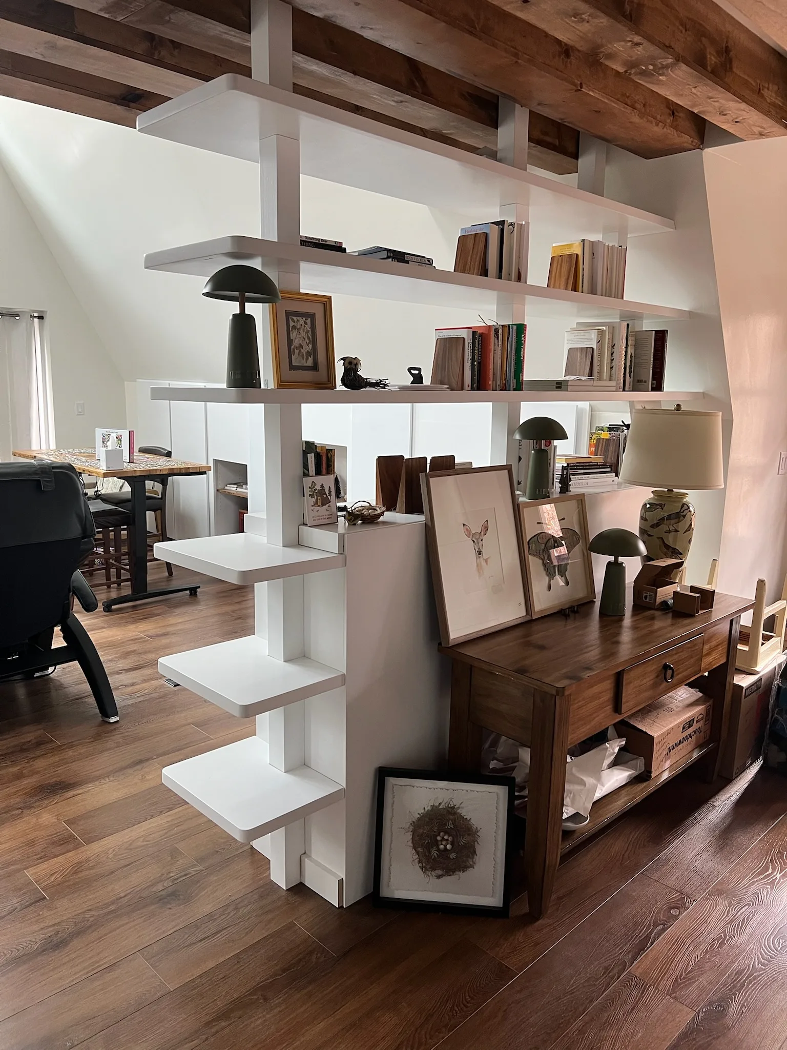 Side view of white bookshelf room divider with styled shelves and console table by Sims Custom Woodwork.