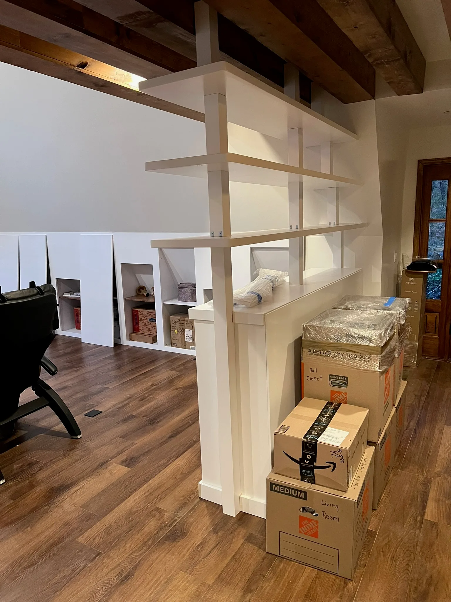 Custom white built-in bookshelf room divider with exposed beam ceiling by Sims Custom Woodwork — serving Chattanooga, TN and North Georgia.