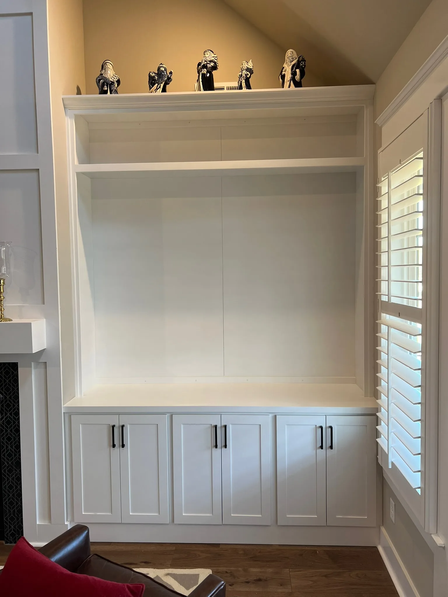 White built-in media niche with shaker lower cabinets and matte black hardware by Sims Custom Woodwork.