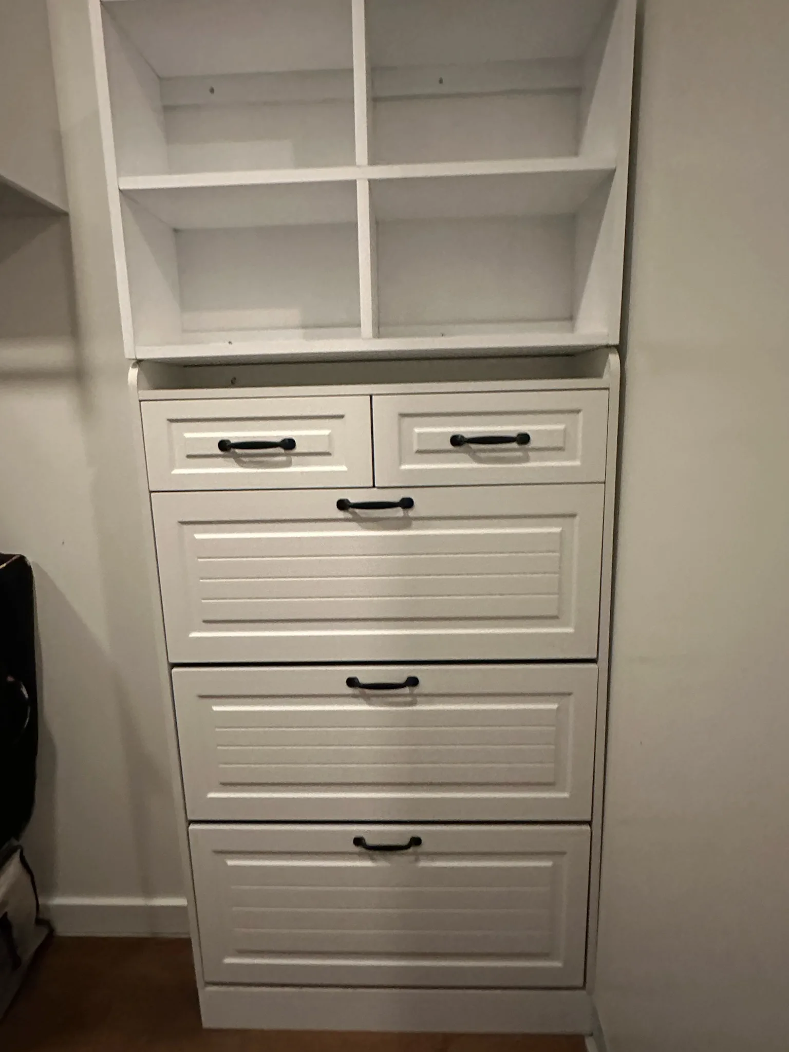 White built-in closet dresser with beadboard drawers and open cubbies by Sims Custom Woodwork.
