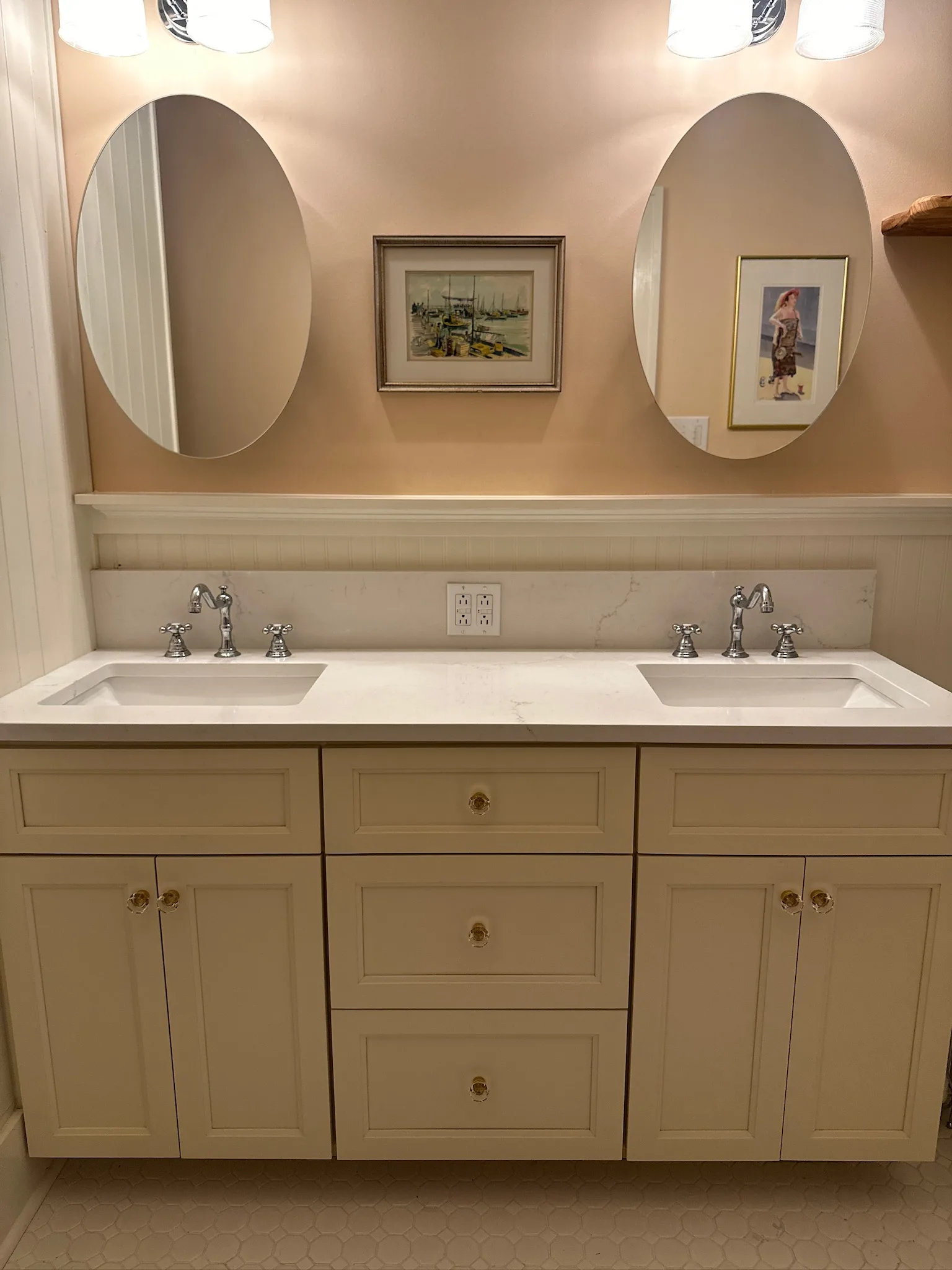 Cream inset double vanity with beadboard wainscoting and quartz top by Sims Custom Woodwork.