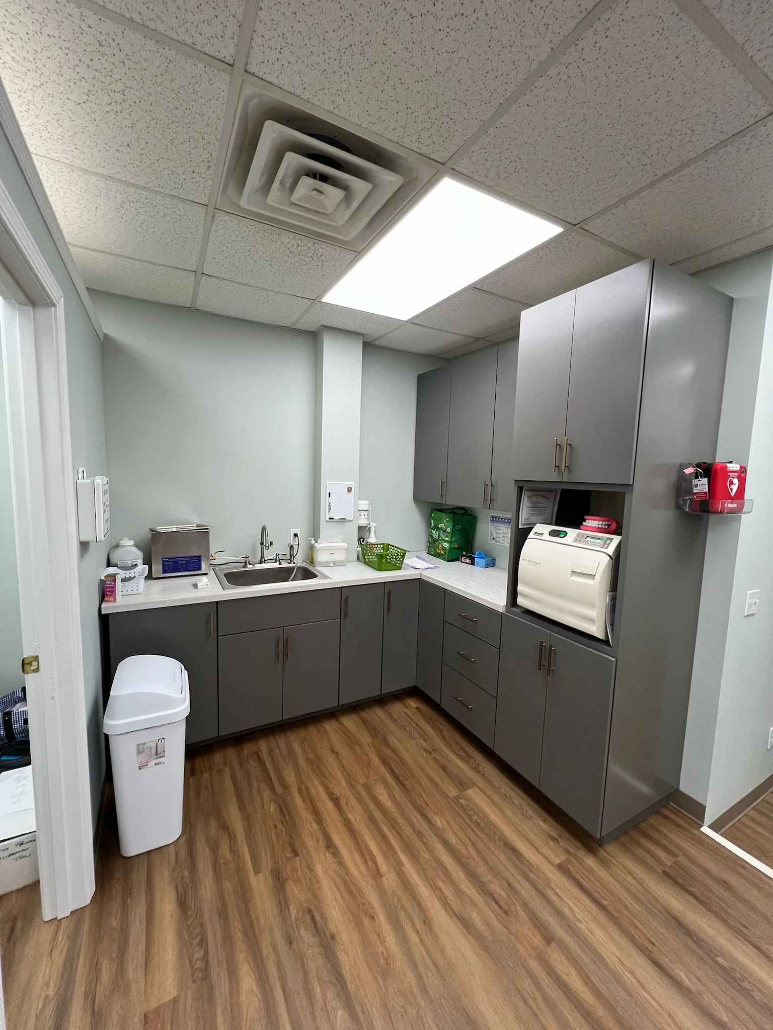 North Georgia dental office commercial cabinetry — sterilization room gray cabinetry and autoclave niche by Sims Custom Woodwork.