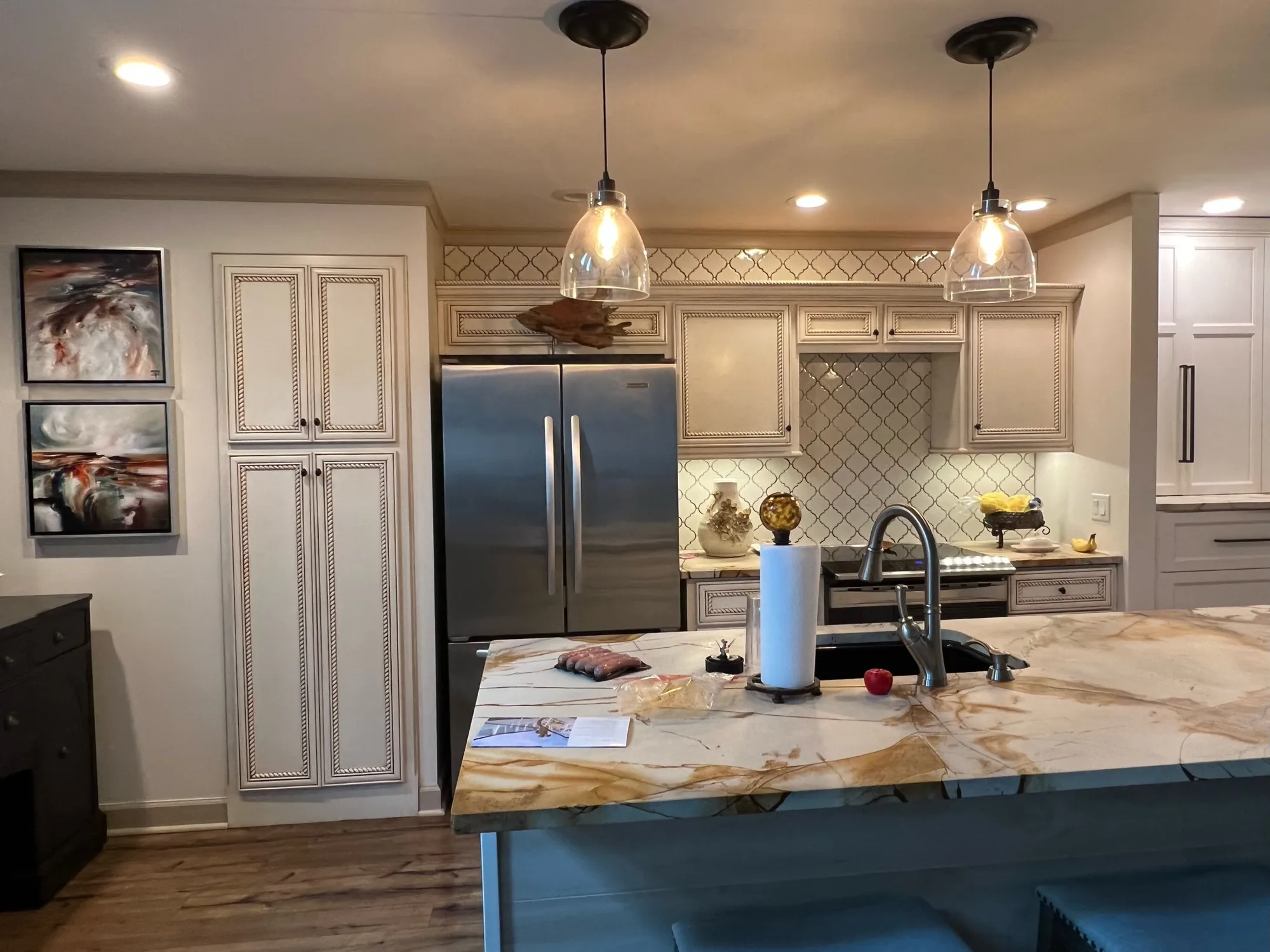 Elegant kitchen with rope-detail cabinets and exotic stone island by Sims Custom Woodwork.
