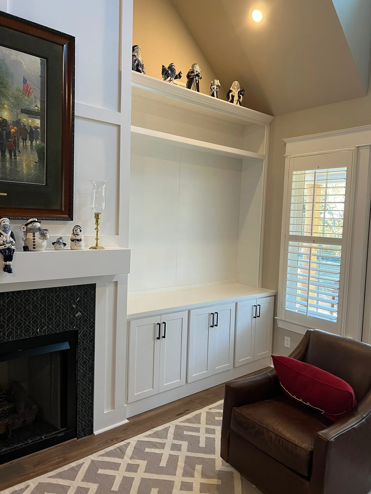 Built-in TV niche with shaker cabinets beside fireplace by Sims Custom Woodwork.