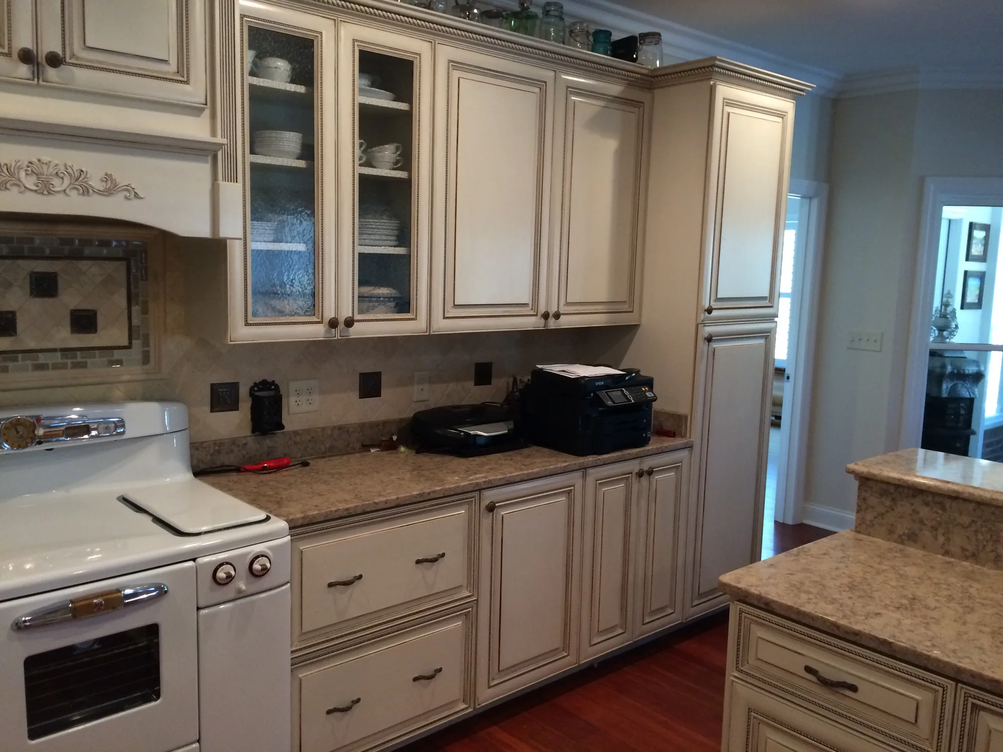 Custom range surround cabinetry with decorative hood by Sims Custom Woodwork.