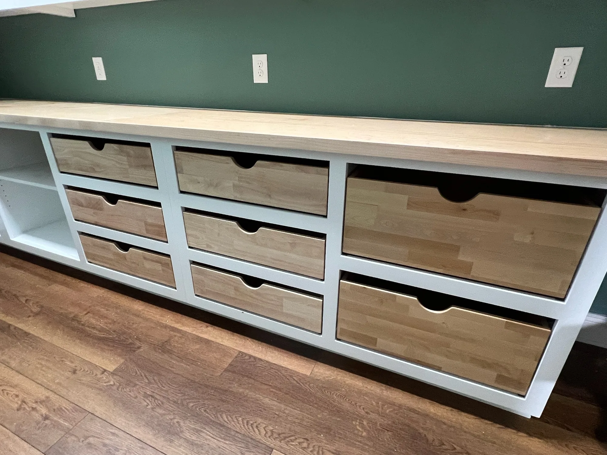 Close-up of natural wood pantry drawers with scoop handles and butcher block counter by Sims Custom Woodwork.