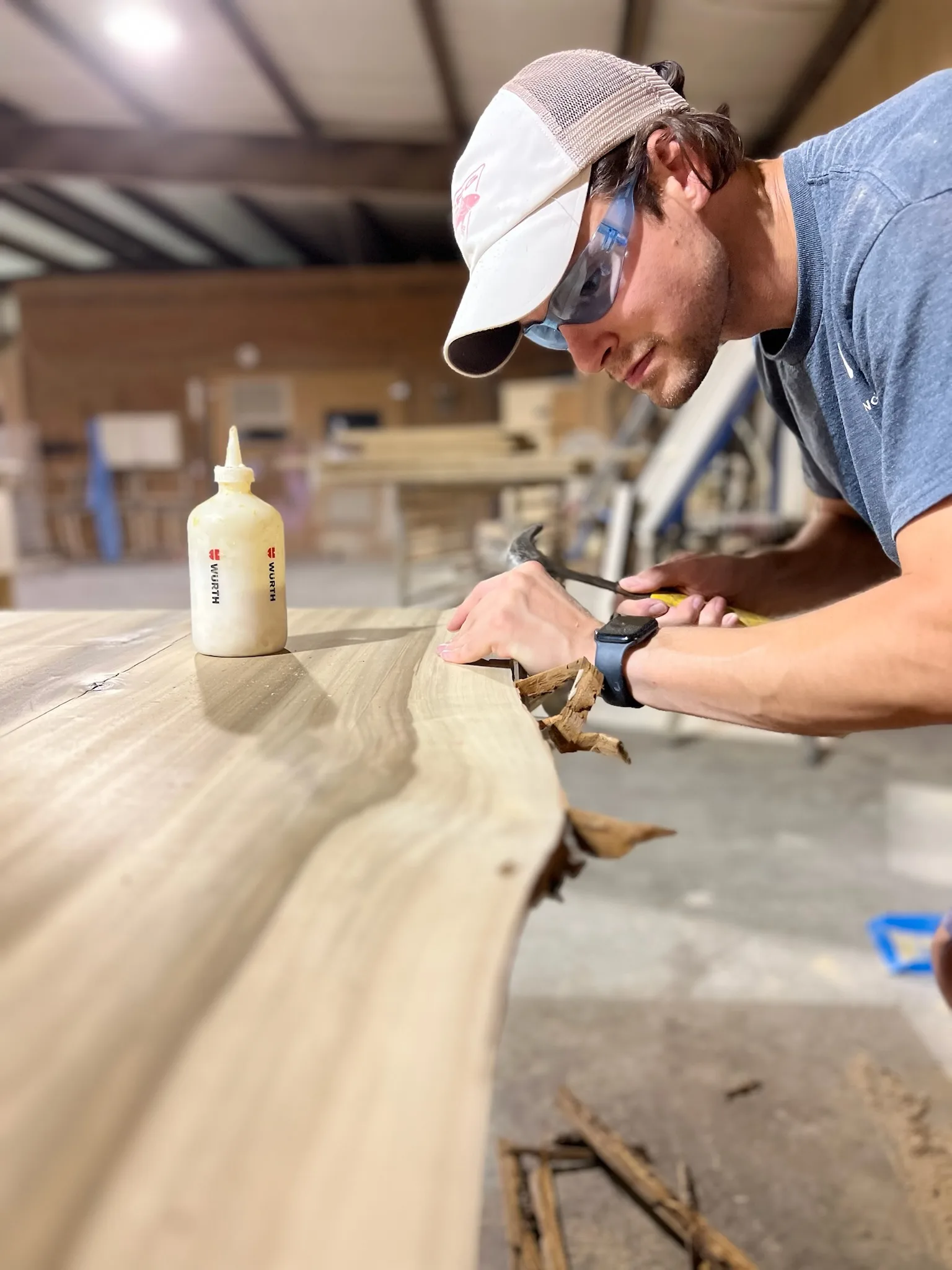 Close-up of live-edge slab bark removal by hand in the Sims Custom Woodwork shop.