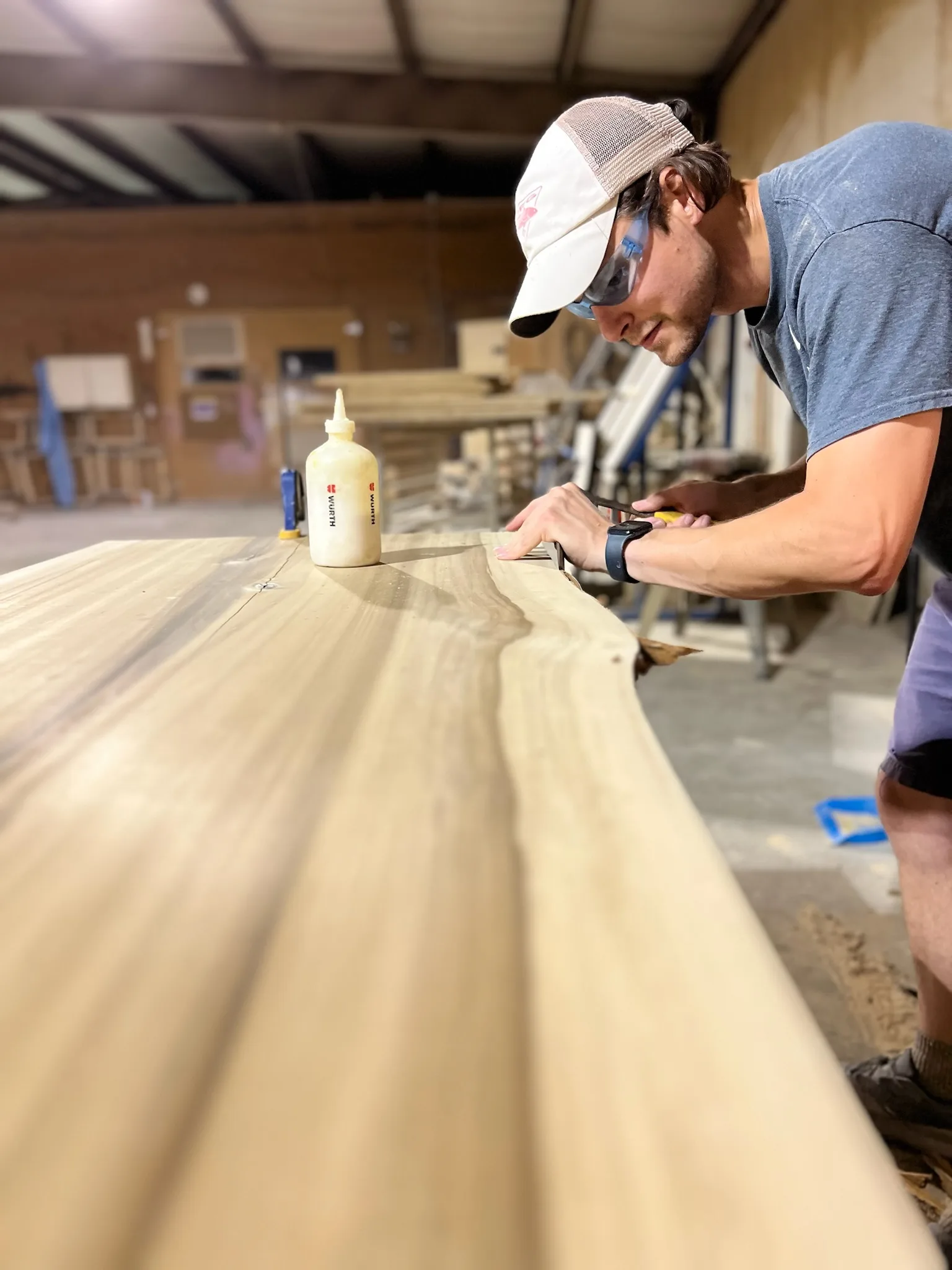 Craftsman prepping a live-edge wood slab in the Sims Custom Woodwork workshop.