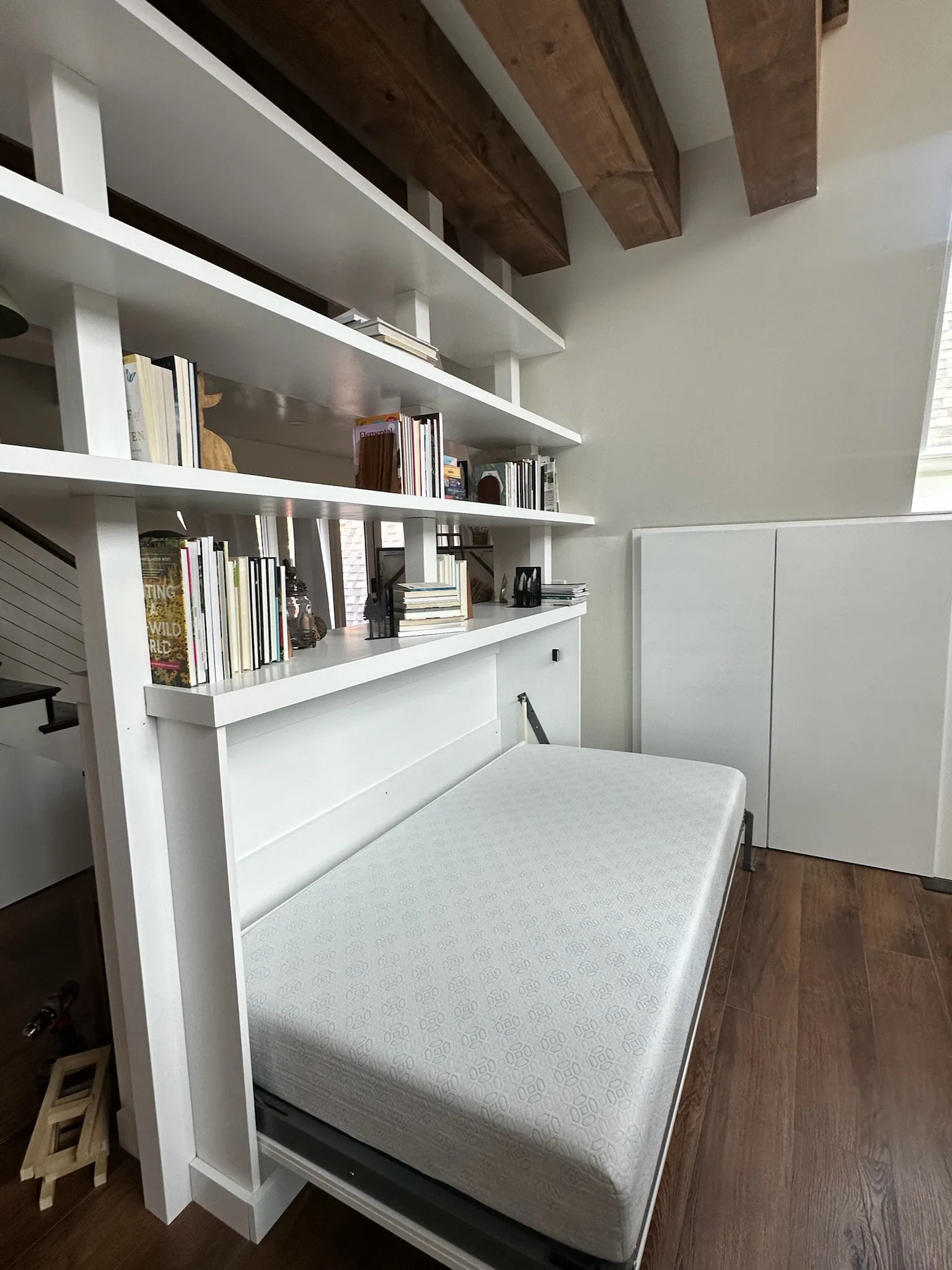 Custom Murphy bed with built-in bookshelf divider by Sims Custom Woodwork.