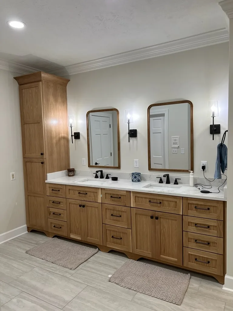 Front view of natural wood double vanity with framed mirrors and black hardware by Sims Custom Woodwork.