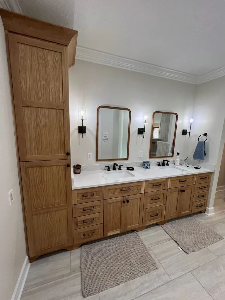 Natural wood bathroom vanity linen tower with drawer storage and black hardware by Sims Custom Woodwork.