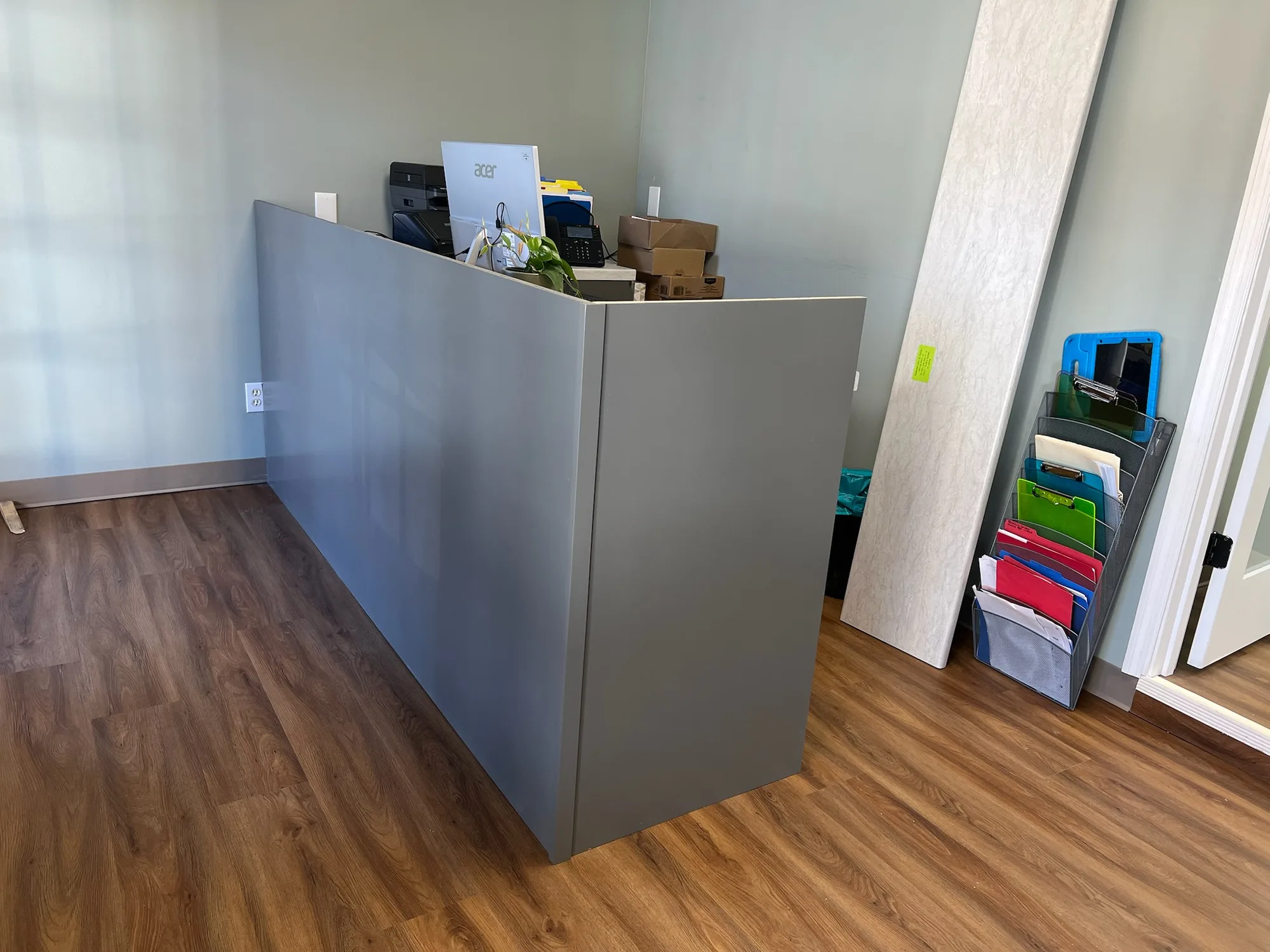 Back panel view of gray reception desk showing clean construction by Sims Custom Woodwork.