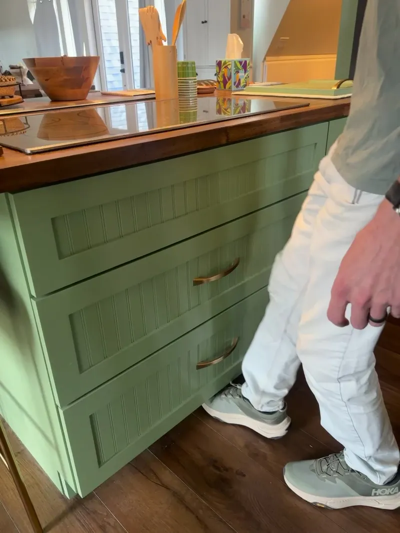 Close-up video of brass hardware on sage green beadboard kitchen drawers by Sims Custom Woodwork.