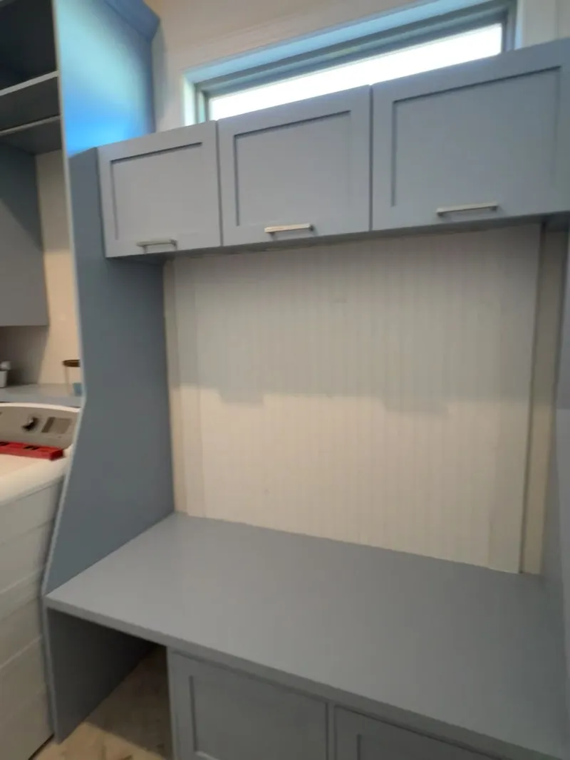 Video tour of blue-grey laundry room folding station with beadboard panel by Sims Custom Woodwork.