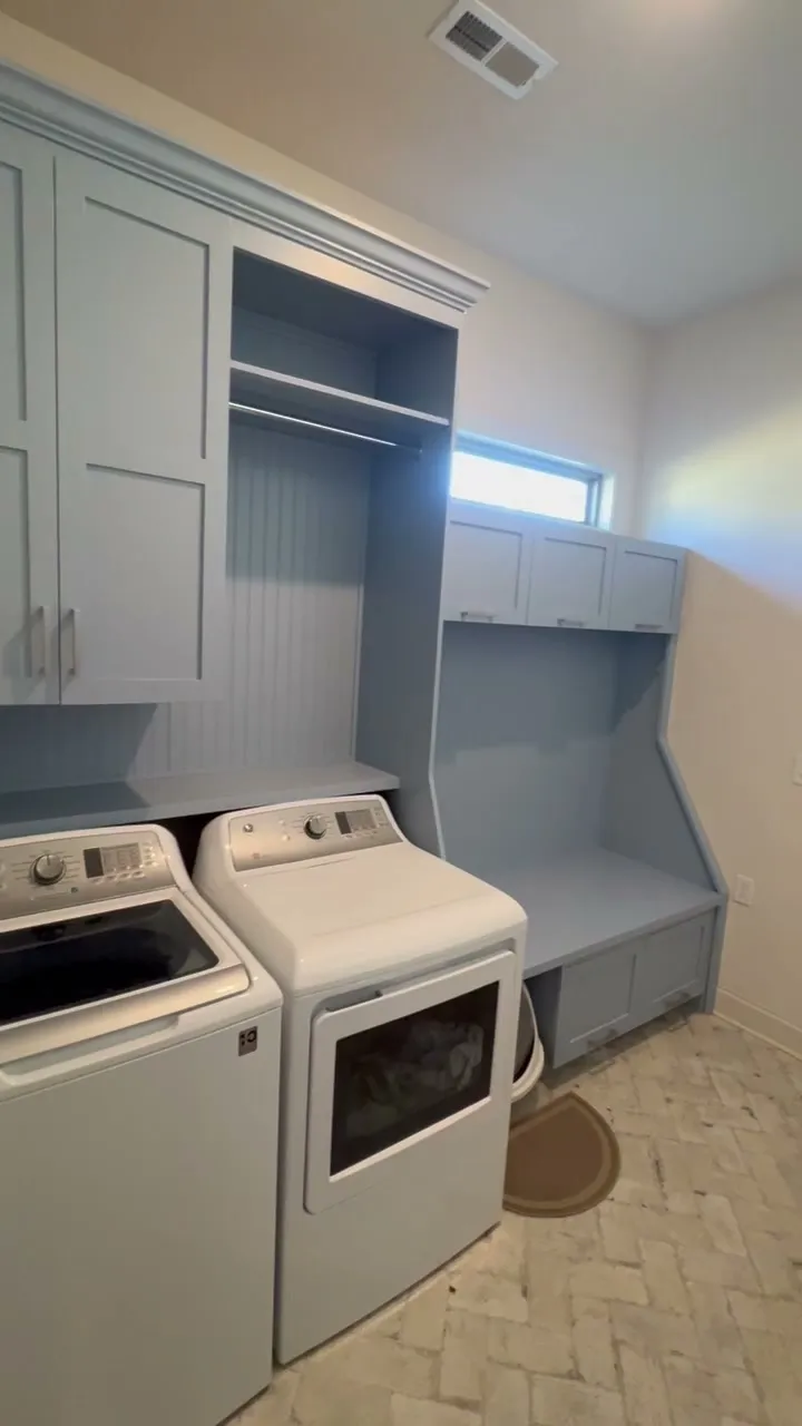 Wide-angle video of full blue-grey laundry room cabinetry system by Sims Custom Woodwork.