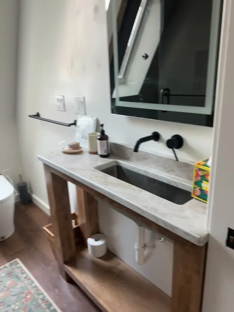 Video detail of rustic open-frame vanity with marble top and wall-mount faucet by Sims Custom Woodwork.