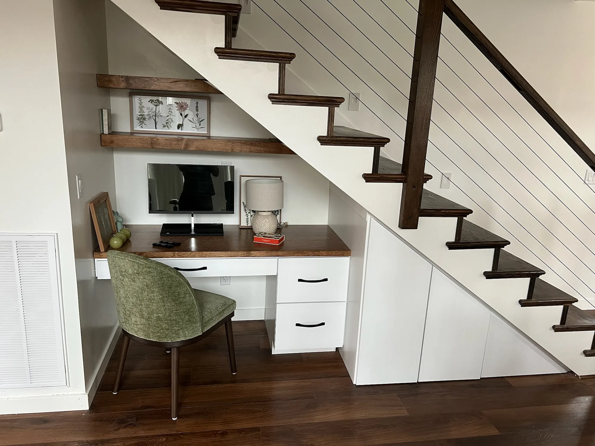 Styled under-stair desk workspace with walnut top and cable railing by Sims Custom Woodwork.