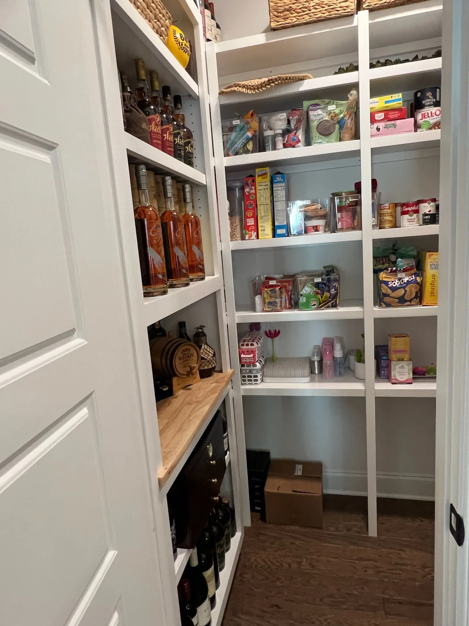 Custom L-shaped walk-in pantry with built-in shelving by Sims Custom Woodwork.