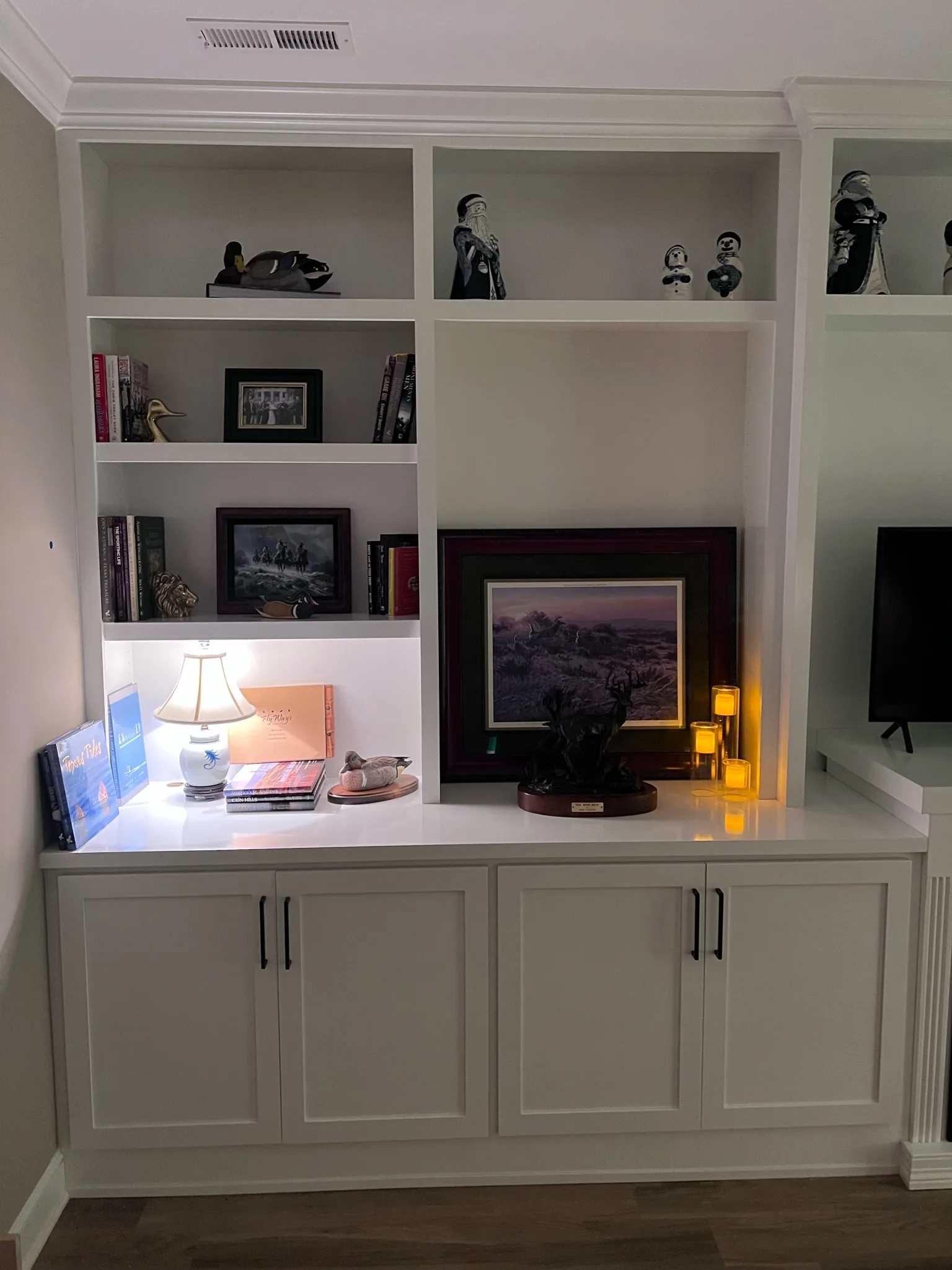 White built-in bookcase with display shelving and shaker base cabinets by Sims Custom Woodwork.