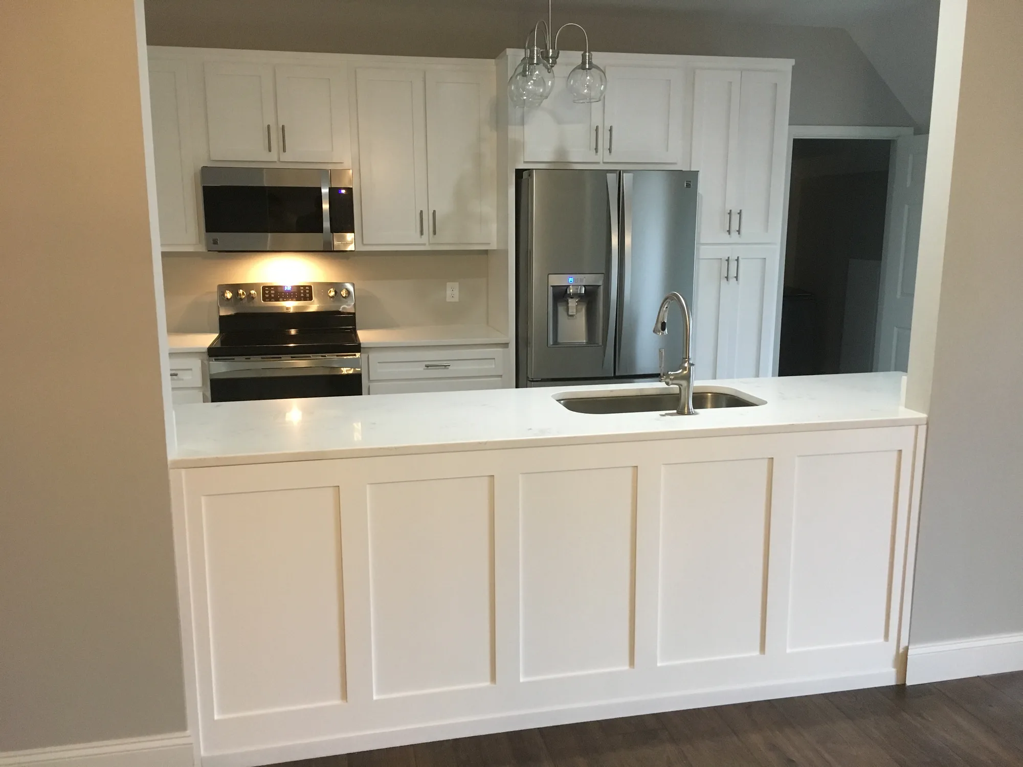 Floor-to-ceiling white pantry cabinets with full overlay doors.